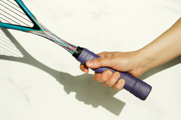 Close-up of correct grip of squash racket. Hand holding racket on white background, space for text