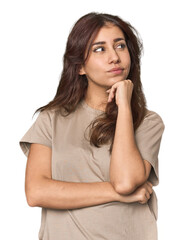 Middle Eastern woman in studio thinking and looking up, being reflective, contemplating, having a fantasy.