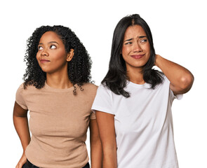 Young Latin friends in studio touching back of head, thinking and making a choice.