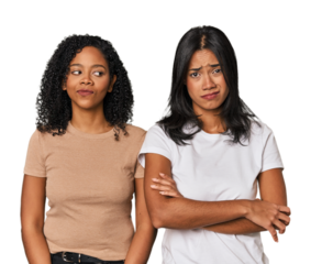 Young Latin friends in studio unhappy looking in camera with sarcastic expression.