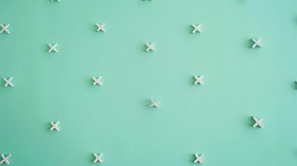 Fototapeta premium Minimalist teal background with small white geometric crosses arranged in a grid pattern, creating a modern and clean aesthetic.