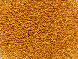 Bee pollen yellow grains top view, background