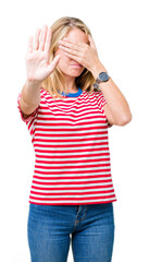 Beautiful young woman wearing glasses over isolated background covering eyes with hands and doing stop gesture with sad and fear expression. Embarrassed and negative concept.