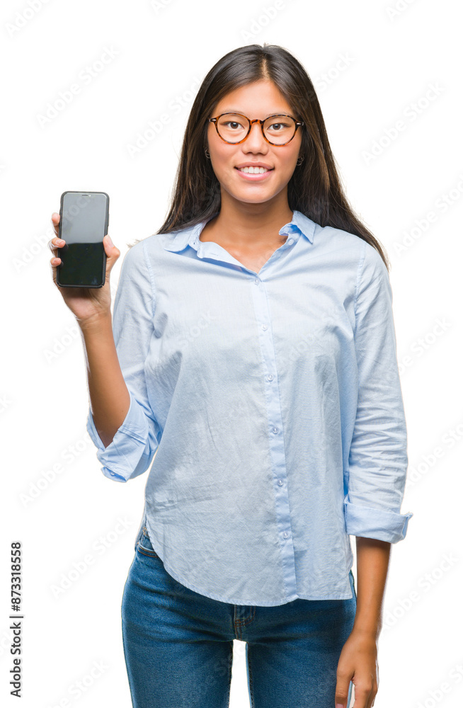 Wall mural young asian woman showing smartphone blank screen over isolated background with a happy face standin