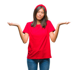 Young asian woman over isolated background clueless and confused expression with arms and hands...