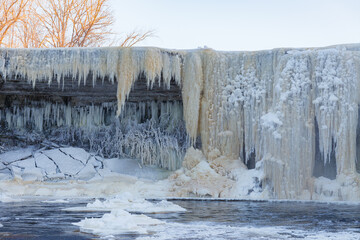 Partially frozen waterfall Jagala juga, Estonia. Water falling from fractured limestone plate