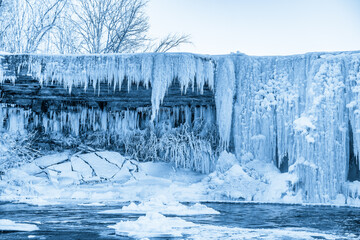 Partially frozen waterfall Jagala juga, Estonia. Water falling from fractured limestone plate