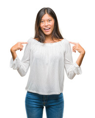 Young asian woman over isolated background looking confident with smile on face, pointing oneself...