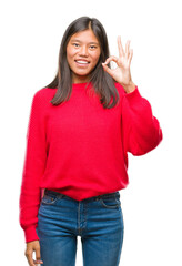 Young asian woman wearing winter sweater over isolated background smiling positive doing ok sign with hand and fingers. Successful expression.