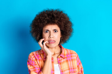 Photo portrait of lovely young lady bite nails frightened dressed stylish checkered garment isolated on blue color background