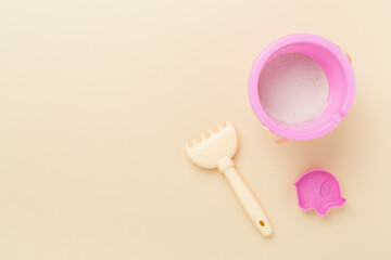 Cute toys for playing with sand on color background, top view