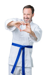 Obraz premium Handsome middle age senior man wearing kimono uniform over isolated background smiling in love showing heart symbol and shape with hands. Romantic concept.