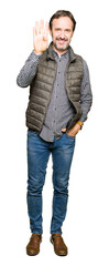 Fototapeta premium Middle age handsome man wearing winter vest showing and pointing up with fingers number four while smiling confident and happy.