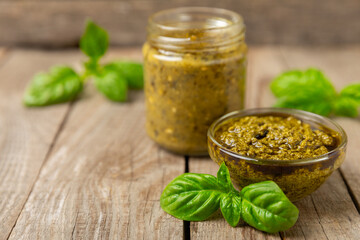Pesto. Italian basil pesto sauce on a textured wooden background. Ingredient for pesto sauce: fresh...