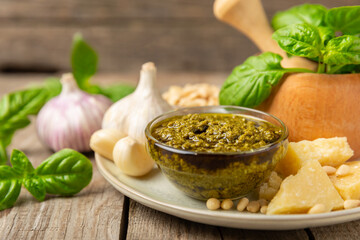 Pesto. Italian basil pesto sauce on a textured wooden background. Ingredient for pesto sauce: fresh...