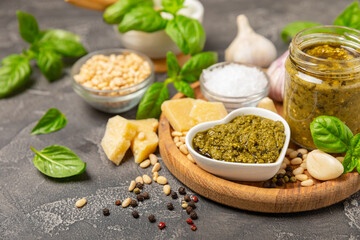 Pesto. Italian basil pesto sauce on a textured wooden background. Ingredient for pesto sauce: fresh...