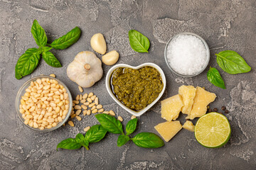 Pesto. Italian basil pesto sauce on a textured wooden background. Ingredient for pesto sauce: fresh...