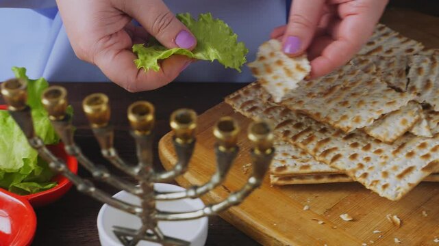 Jewish woman dips karpas in salt water during Pesach Seder meal. Medium plan.