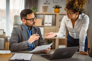 Two colleagues read and talk about document from envelope post letter