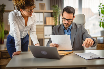 Obraz premium Two colleagues read and talk about document from envelope post letter