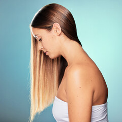 Naklejka premium Shine, long and woman with hair care, wellness or pride for cosmetics, results and keratin treatment. Relax, girl or model in studio on blue background for healthy glow, natural growth and beauty