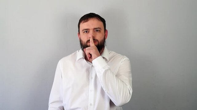 Man Signaling to Be Quiet with Finger to Lips And Stop Talking. Silence gesture