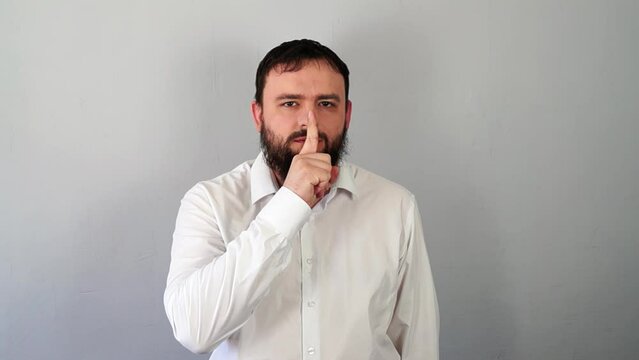 Man Signaling to Be Quiet with Finger to Lips And Stop Talking. Silence gesture