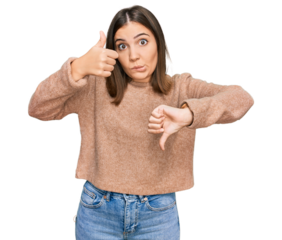 Young beautiful woman wearing casual clothes doing thumbs up and down, disagreement and agreement expression. crazy conflict