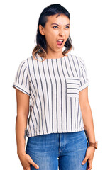 Fototapeta premium Young woman wearing casual clothes angry and mad screaming frustrated and furious, shouting with anger. rage and aggressive concept.