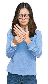Young beautiful woman wearing casual clothes and glasses suffering pain on hands and fingers, arthritis inflammation