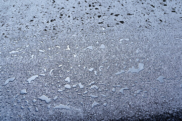 A close-up view of wet pavement covered in water droplets