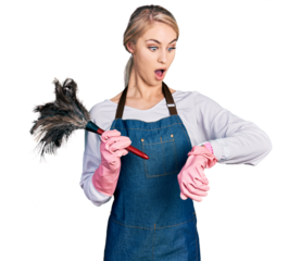 Beautiful young blonde woman wearing apron holding cleaning duster looking at the watch time worried, afraid of getting late