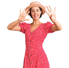 Young beautiful woman wearing summer hat showing and pointing up with fingers number nine while...