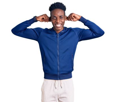 Young african american man wearing sportswear smiling pulling ears with fingers, funny gesture. audition problem