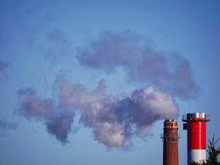 A red and white tower with smoke coming out of it. stockphoto.