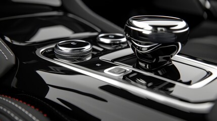 A detailed view of the pushstart button and gear shift both encased in glossy black and silver finishes exuding a sense of power and luxury.
