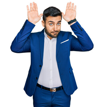 Young hispanic man wearing business jacket doing bunny ears gesture with hands palms looking cynical and skeptical. easter rabbit concept.