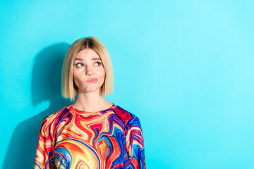 Fototapeta premium Photo of minded girl with bob hairstyle dressed print shirt thoughtfully look empty space offer isolated on turquoise color background