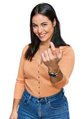 Young hispanic woman wearing casual clothes beckoning come here gesture with hand inviting welcoming happy and smiling