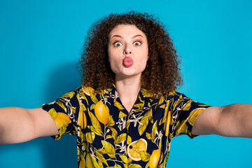 Photo of cheerful pretty lady dressed print shirt tacking selfie sending you kiss empty space isolated blue color background