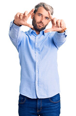 Young handsome blond man wearing elegant shirt doing frame using hands palms and fingers, camera perspective