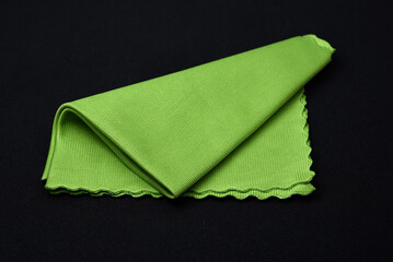 A green cleaning cloth on a black background.