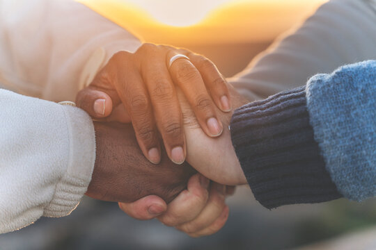 Close-up of Multicultural Diverse Hands Clasped Together at Sunset