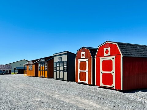 American style wooded sheds in a row. A shed is typically simple, single-story roofed structure in a back garden or on an allotment that is used for storage, hobbies, or as a workshop.