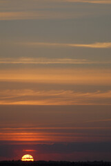 Yellow disk of the sun in the evening sky.