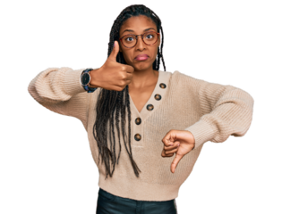 African american woman wearing casual clothes doing thumbs up and down, disagreement and agreement expression. crazy conflict