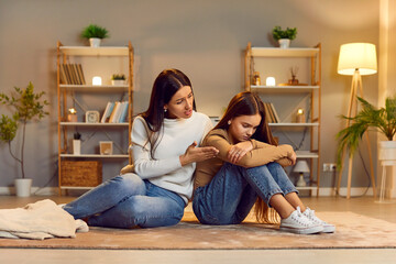 Mother comforting sad child. Worried mom and mad, distressed kid daughter sitting on floor, talking...
