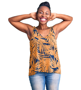 Young african american woman wearing casual clothes relaxing and stretching, arms and hands behind head and neck smiling happy