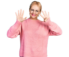 Young blonde woman wearing casual clothes and glasses showing and pointing up with fingers number...