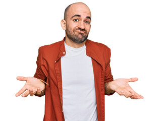 Young hispanic man wearing casual clothes clueless and confused expression with arms and hands...